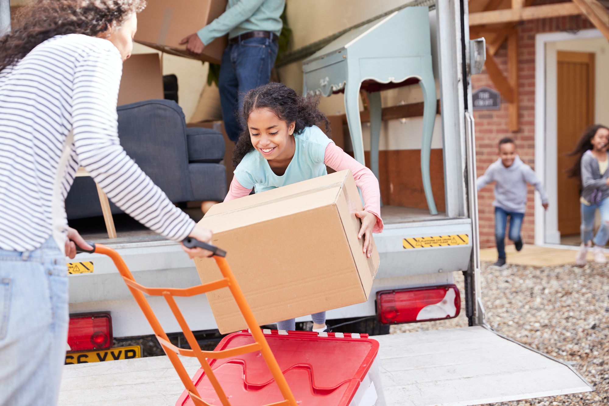 family-unloading-furniture-from-removal-truck-into-new-home