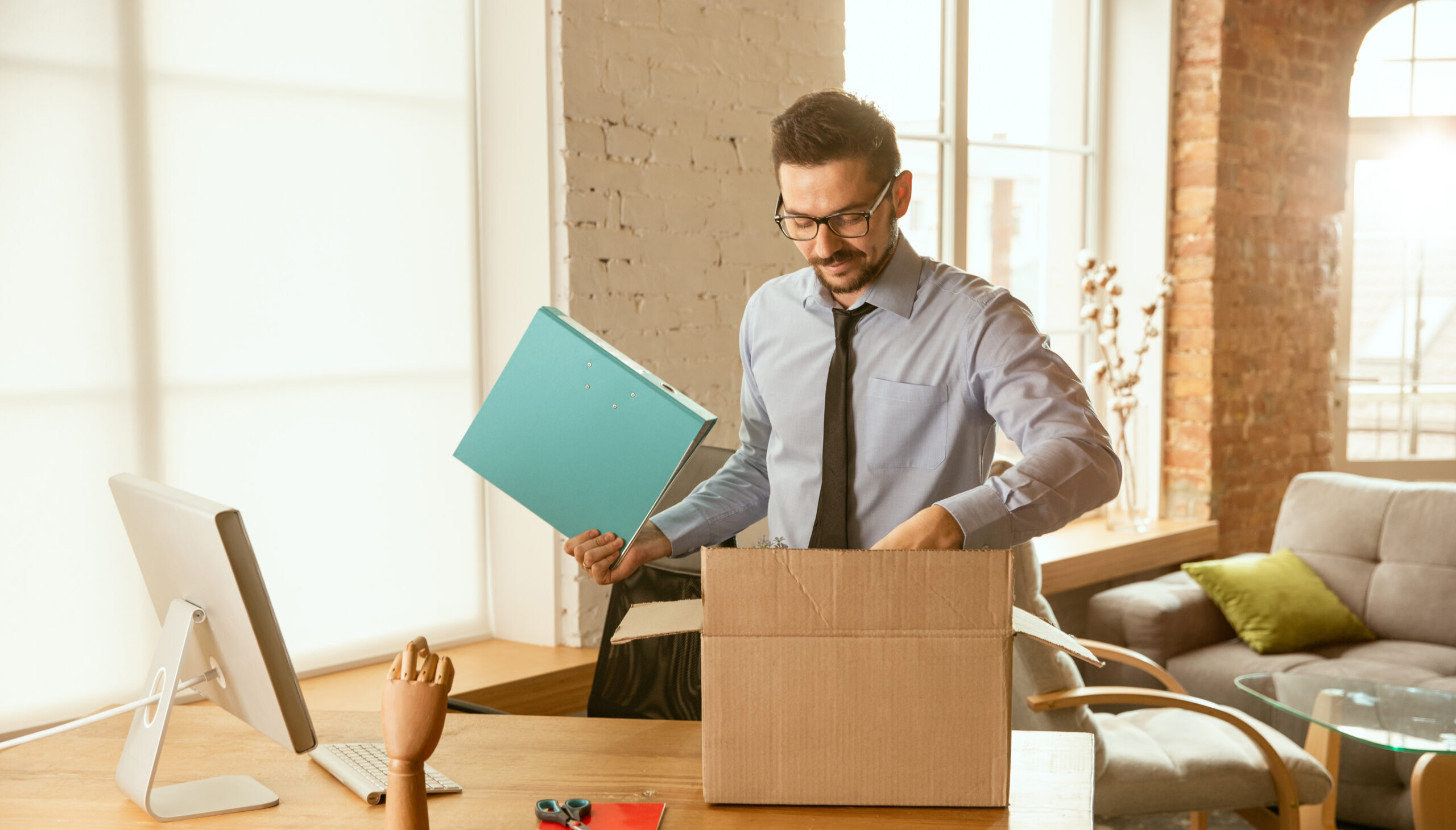 young-businessman-moving-office-getting-new-work-place-scaled